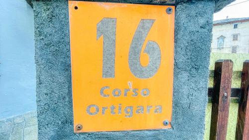 a yellow sign on a wall with the number at Appartamento Ortigara 16 - Affitti Brevi Italia in Oulx