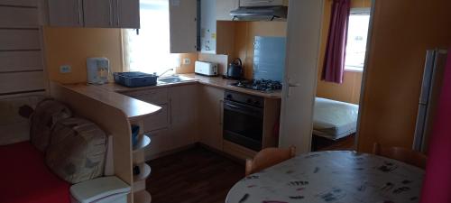 - une petite cuisine avec une table et un comptoir dans l'établissement MH372 camping Bois Dormant 6pers, à Saint-Jean-de-Monts