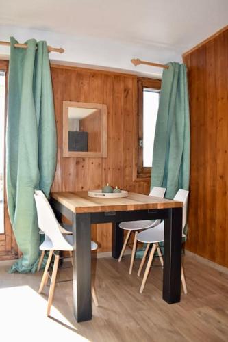 une salle à manger avec une table et des chaises en bois dans l'établissement Appartement Cosy, La Rosière, 300m du téléski gratuit de Manessier, à Montvalezan