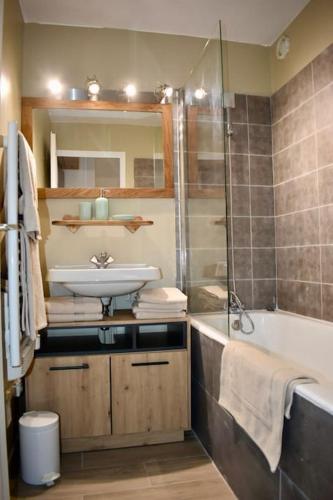 une salle de bain avec un lavabo et une baignoire dans l'établissement Appartement Cosy, La Rosière, 300m du téléski gratuit de Manessier, à Montvalezan