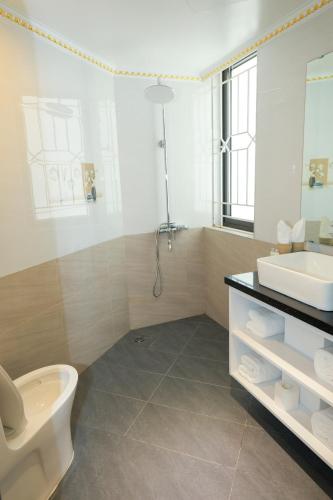 a bathroom with a toilet and a sink at Royal Hotel Trâu Quỳ in Thạch Cầu