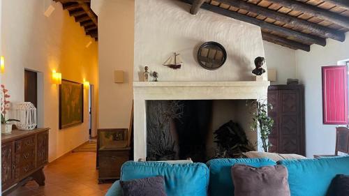 a living room with a blue couch and a fireplace at Monte Frecae in Alandroal