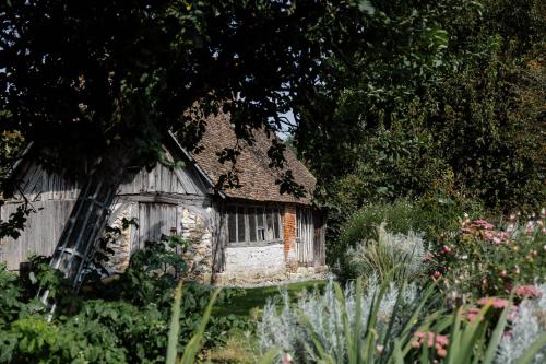 an old house in the middle of a garden at LA MOTTE FÉODALE luxury medieval MANOR rated 5 stars in Normandy in Le Mesnil-Jourdain