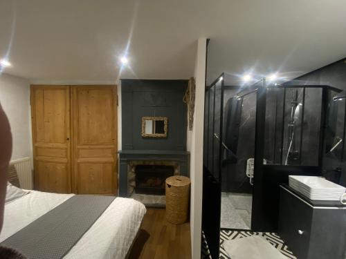 une chambre avec un lit et une cheminée dans l'établissement Le clos de la Pommeraie Carly, à Carly