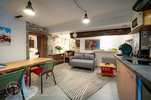 une cuisine et un salon avec une table et un canapé dans l'établissement Le refuge du bout du monde, à Leysse