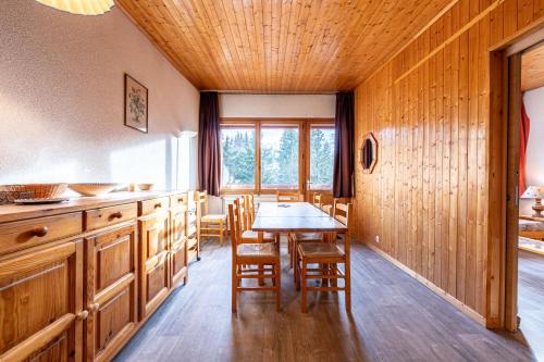 une cuisine avec des armoires en bois et une table et des chaises dans l'établissement Appartement 26 - 9 personnes, à Les Allues