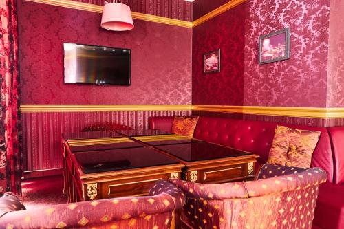 a red room with a table and two chairs at Kainar Hotel in Shymkent