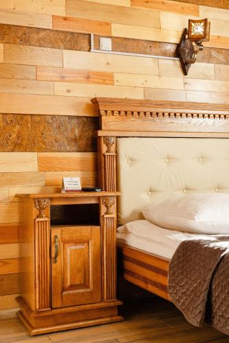 a bedroom with a bed and a wooden wall at Zatyshok nad Prutom in Bukovel
