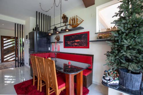 a dining room with a red table and a christmas tree at Ombe Villa in Labuan Lombok