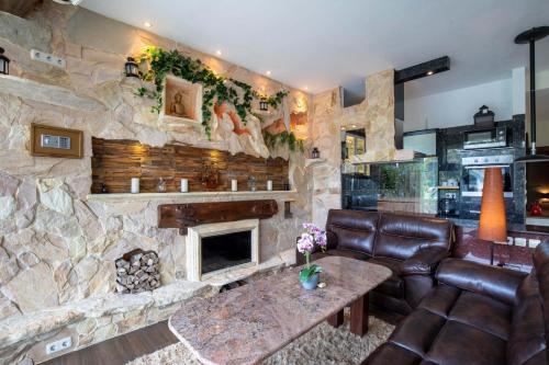 a living room with a stone wall with a fireplace at Ombe Villa in Labuan Lombok