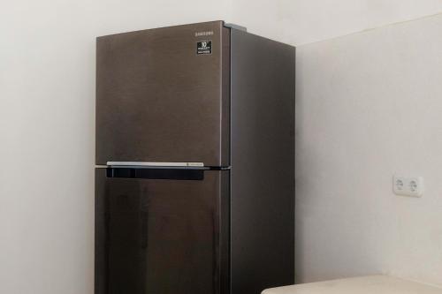 a stainless steel refrigerator in the corner of a room at Ombe Villa in Labuan Lombok