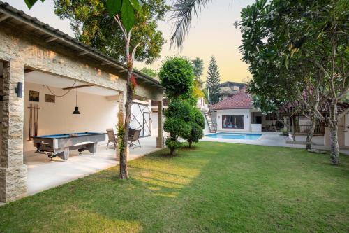 a backyard with a pool table and a house at Ombe Villa in Labuan Lombok