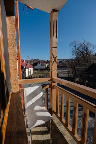 a white chair sitting on a porch with a view at Zatyshok nad Prutom in Bukovel