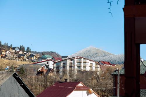 a town with houses and a mountain in the background at Zatyshok nad Prutom in Bukovel