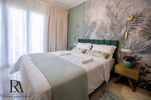 une chambre avec un grand lit avec des draps blancs dans l'établissement Roksen Apartments JUNGLE, à Ioannina