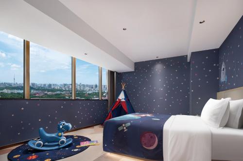 a bedroom with a blue wall with stars and a bed at 长沙荔高尊享酒店 in Changsha