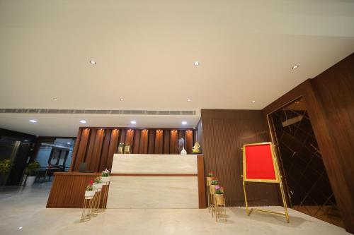 a lobby with a reception desk and a red chair at Hotel The RS Casa - Agra in Agra