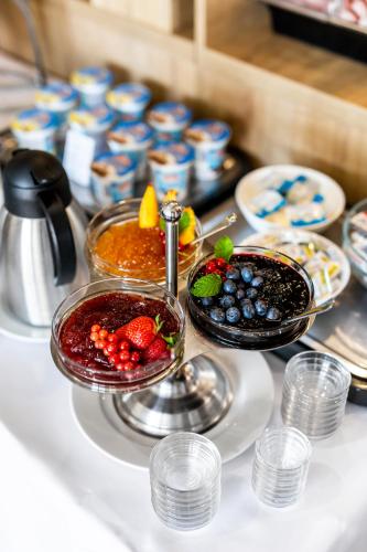 a table topped with bowls of fruit and sauce at Hilson Jasna - Garden resort in Liptovský Mikuláš