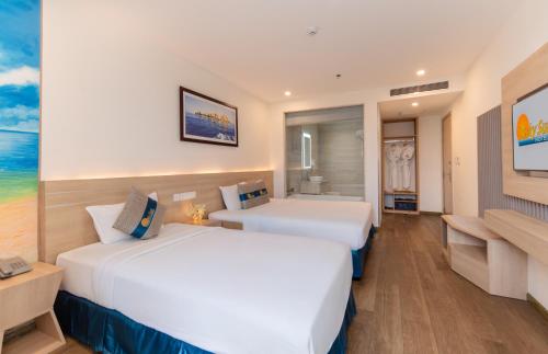 a hotel room with two beds and a bathroom at Lucky Sun Hotel Nha Trang Beach in Nha Trang