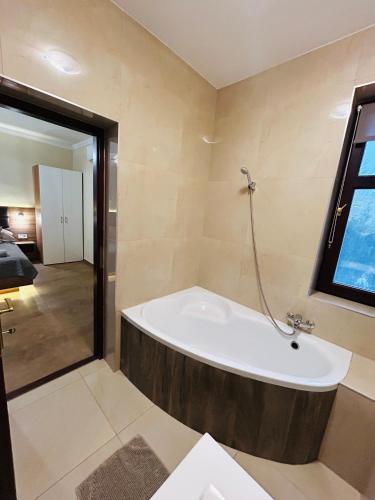 a bath tub in a bathroom with a window at Harmónia Vendégház in Miskolctapolca