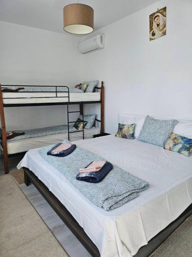 a bedroom with a bed with two bunk beds at Бадевски рай-къща Вяра in Badewzi
