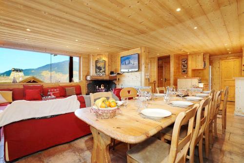 une salle à manger avec une grande table et des chaises en bois dans l'établissement Charming chalet 8 en suite bedrooms, à La Tania