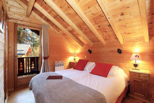 une chambre avec un lit dans une cabane en bois dans l'établissement Charming chalet 8 en suite bedrooms, à La Tania