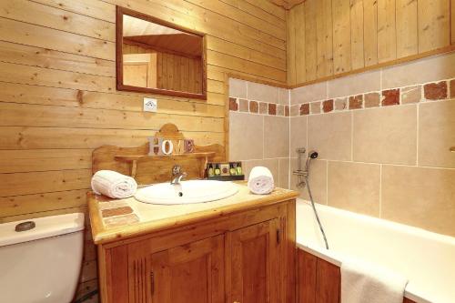 une salle de bain avec un lavabo, des toilettes et une baignoire dans l'établissement Charming chalet 8 en suite bedrooms, à La Tania