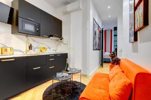 un salon avec un canapé orange et une cuisine dans l'établissement 206 Suite Hermès - Superb apartment in Paris, à Paris