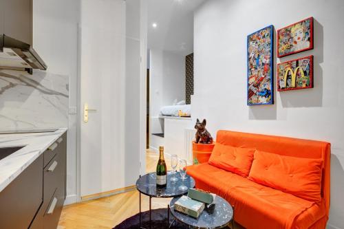 un salon avec un canapé orange et une table dans l'établissement 206 Suite Hermès - Superb apartment in Paris, à Paris