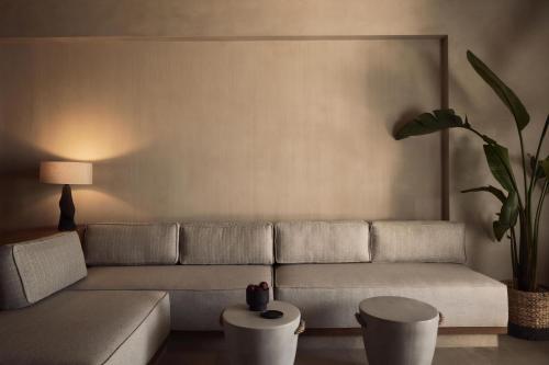 a living room with a couch and a potted plant at Zelia Halkidiki, part of Destination by Hyatt - Adults Only in Nea Potidaea