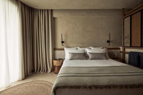 a bedroom with a large bed with white pillows at Zelia Halkidiki, part of Destination by Hyatt - Adults Only in Nea Potidaea