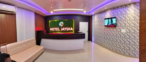 グワーハーティーにあるHotel Jayshaのソファと壁掛けテレビのあるロビー