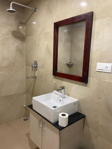 un bagno con lavandino, specchio e doccia di Vrindavan Greens Resort a Udaipur