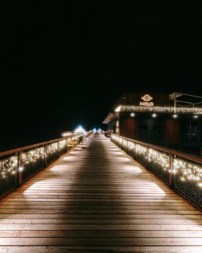 a wooden bridge at night with lights on it at MOLO LIPNO RESIDENCE in Lipno nad Vltavou