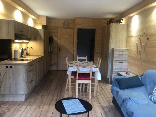 une cuisine et un salon avec une table et un canapé dans l'établissement Le refuge, à Saint-Jean-Saint-Nicolas