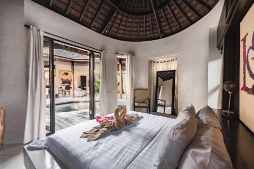 a woman laying on a bed in a bedroom at Sandi Kala Villas in Kerobokan