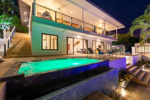 a villa with a swimming pool at night at Here and Now - Luxury Sea view & Spa Villa in Koh Samui 