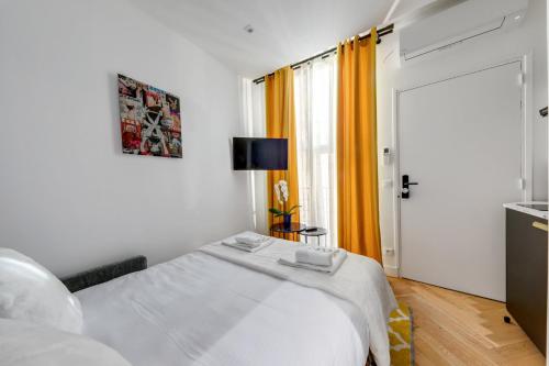 une chambre blanche avec un lit et une fenêtre dans l'établissement Suite CD : Superb Parisian apartment, à Paris