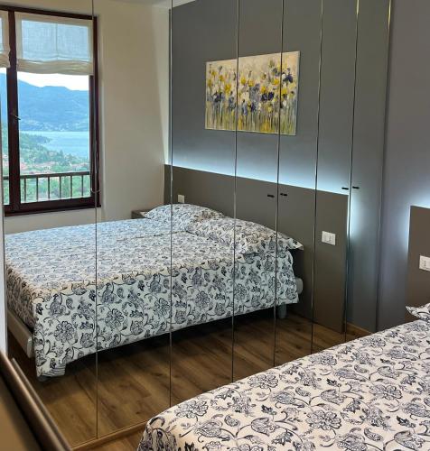 two beds in a room with glass walls at NEW Luxury Apartment - Menaggio in Menaggio