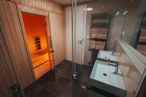 a bathroom with a sink and a shower and a mirror at MOLO LIPNO RESIDENCE in Lipno nad Vltavou