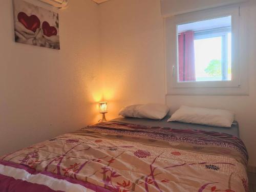 un lit dans une chambre avec une fenêtre dans l'établissement Appartement 2 pièces cabine CAP D'AGDE CT045-151, au Cap d'Agde