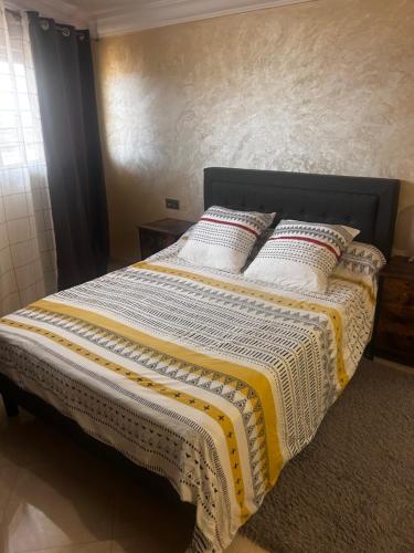 アガディールにあるAppartement haut standing à 5min de la plage2の白と黄色の毛布が敷かれたベッド