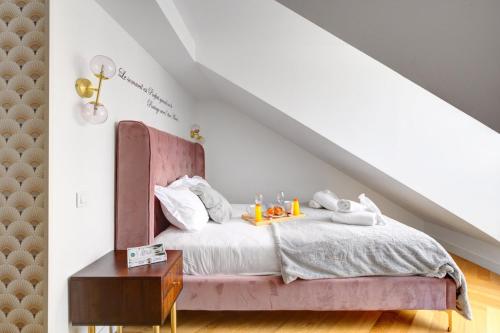 - une chambre avec un lit et une tête de lit rose dans l'établissement 214 Suite Vuitton - Superb Apartment in Paris, à Paris