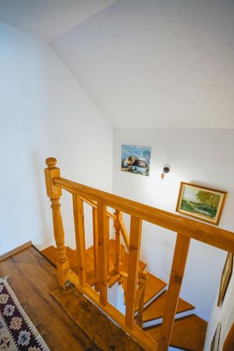 a wooden staircase in a house with two pictures on the wall at Prispa Casei in Floreşti
