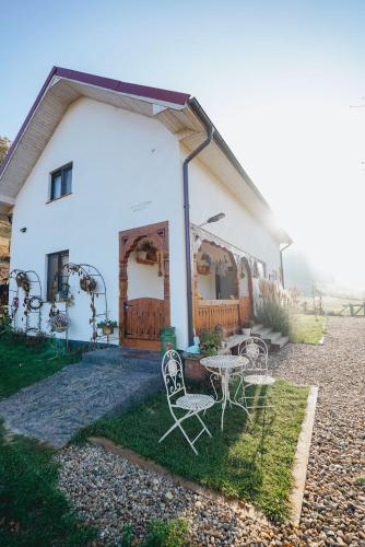 a house with a table and chairs in front of it at Prispa Casei in Floreşti