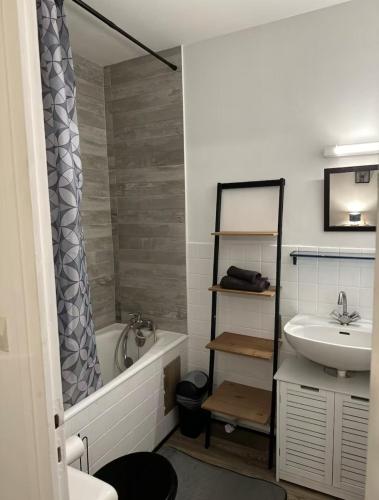 une salle de bain avec un lavabo, une baignoire et des toilettes dans l'établissement Studio meublé Florella proximité GARE-wifi, à Tonneins