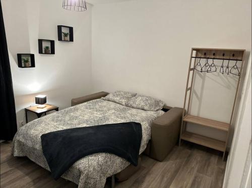 - une chambre avec un lit et une couverture noire dans l'établissement Studio meublé Florella proximité GARE-wifi, à Tonneins