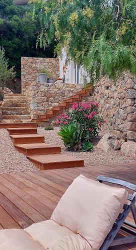 d'un jardin avec des marches en bois et un mur en pierre. dans l'établissement NOUVEAU VISTA CORSICA vue à couper le souffle, à Sotta