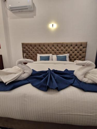 a bedroom with a large bed with blue pillows at ThiThi's Palace Mirissa in Mirissa